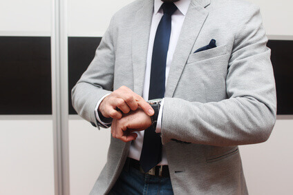 Homme en costume gris avec cravate, pince à cravate et pochette